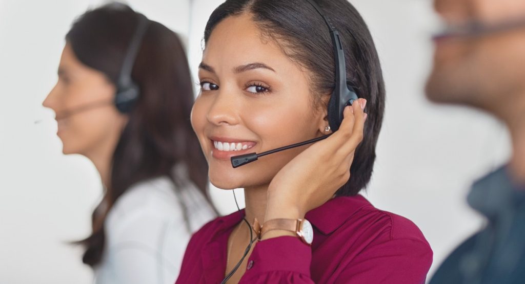 Agente centre d'appels souriante avec casque illustrant les offres et tarifs du logiciel Ringover VoIP