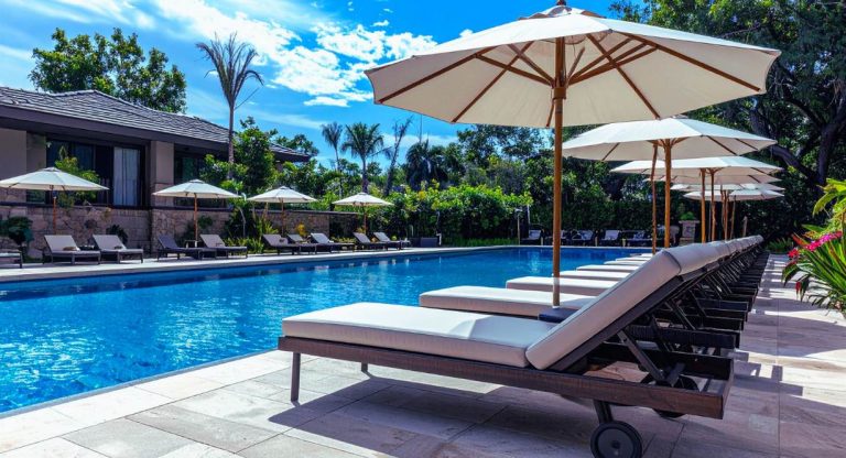 Piscine extérieure de resort de luxe avec transats et parasols illustrant le cadre de travail des GO Club Med