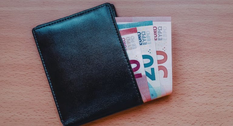 Portefeuille en cuir noir avec billets euros représentant un salaire net mensuel