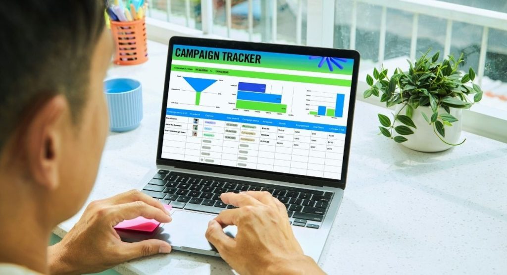 Une personne analyse un tableau de bord de suivi de campagne marketing sur son ordinateur portable